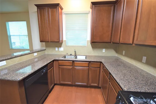a kitchen with granite countertop a sink and a stove