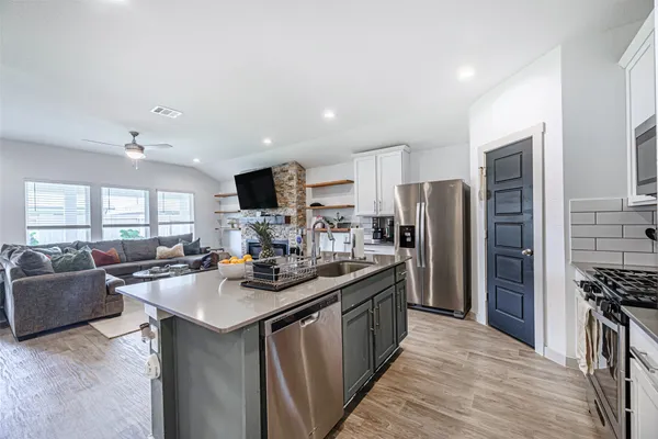 a kitchen with stainless steel appliances granite countertop a sink stove and refrigerator