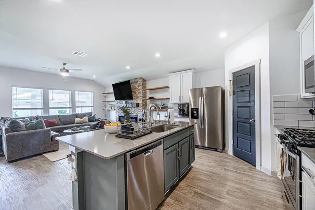 a kitchen with stainless steel appliances granite countertop a sink stove and refrigerator