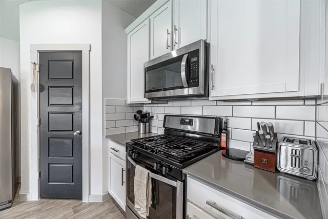 a kitchen with stainless steel appliances granite countertop a stove and a microwave