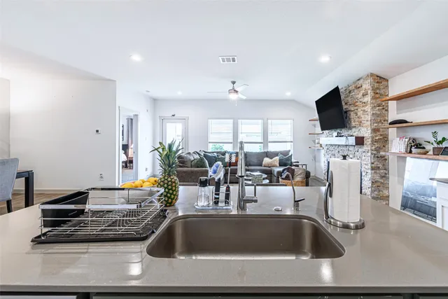 a kitchen with kitchen island a counter top space a sink and cabinets