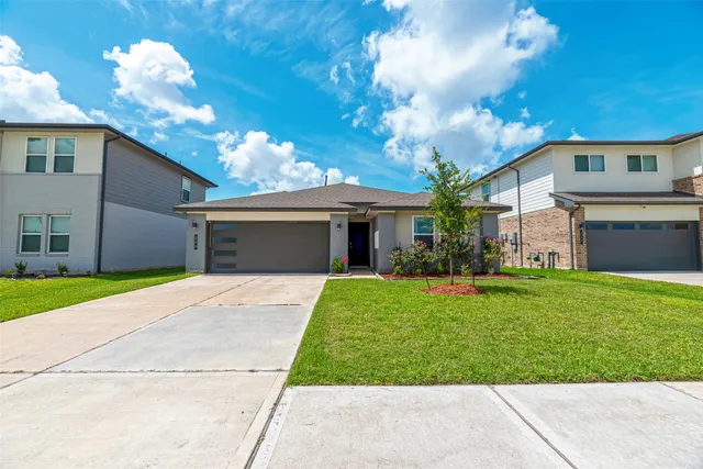 a front view of a house with a garden and yard