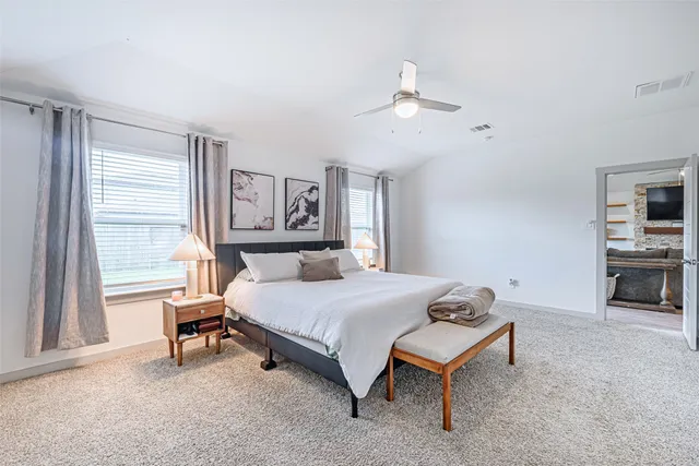 a bedroom with a bed a chair and a chandelier