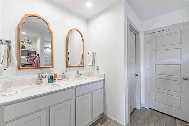 a en suite bathroom with a double vanity sink and a mirror