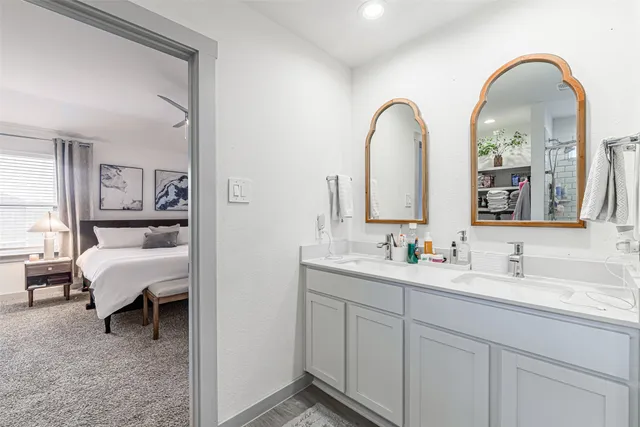 a spacious bathroom with a double vanity sink a mirror and shower