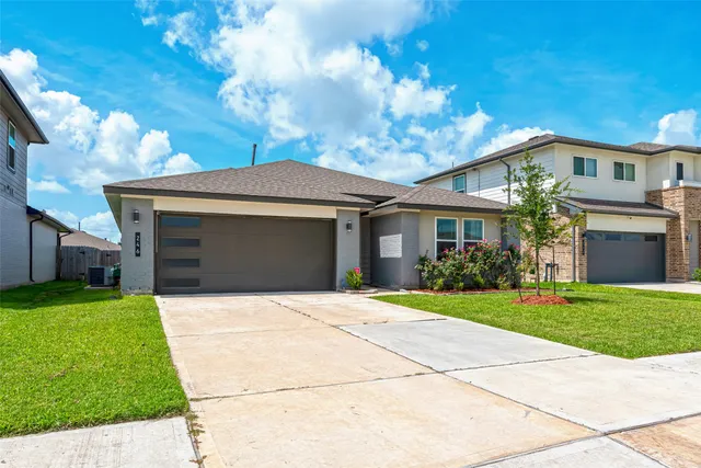 a front view of a house with a garden and trees