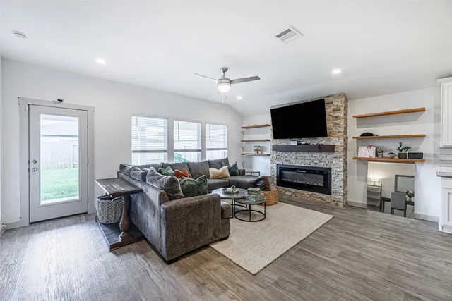 a living room with furniture a fireplace and a flat screen tv