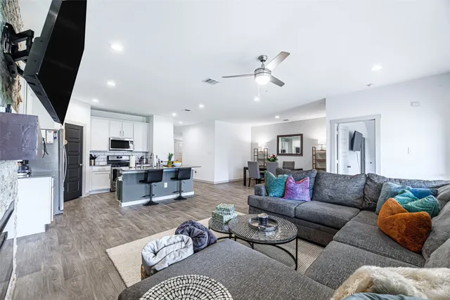 a living room with furniture kitchen view and a chandelier