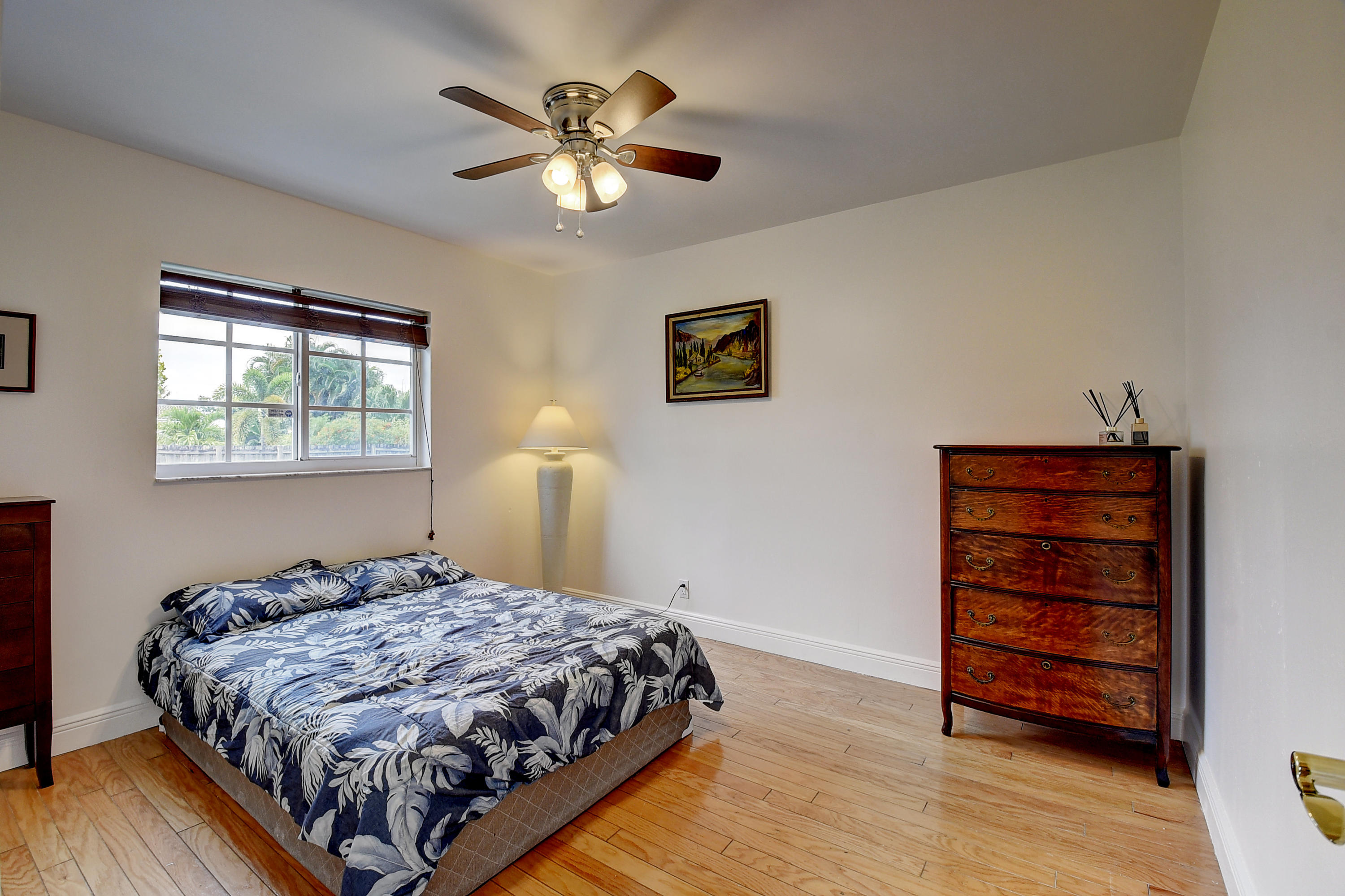 1775 Southwest 8th Street Boca Raton, FL 33486 - Photo 18 of 20 a bedroom with a bed and a chandelier