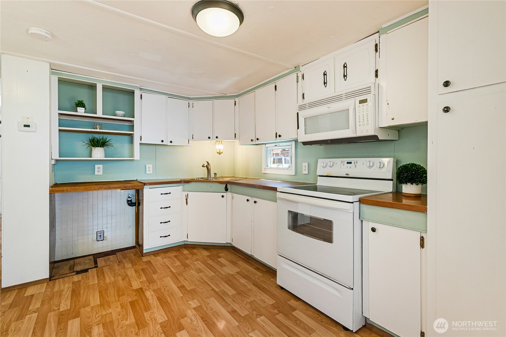 8080 Harborview Road, Unit 167 Blaine, WA 98230 - Photo 13 of 27 a kitchen with granite countertop white cabinets and white appliances