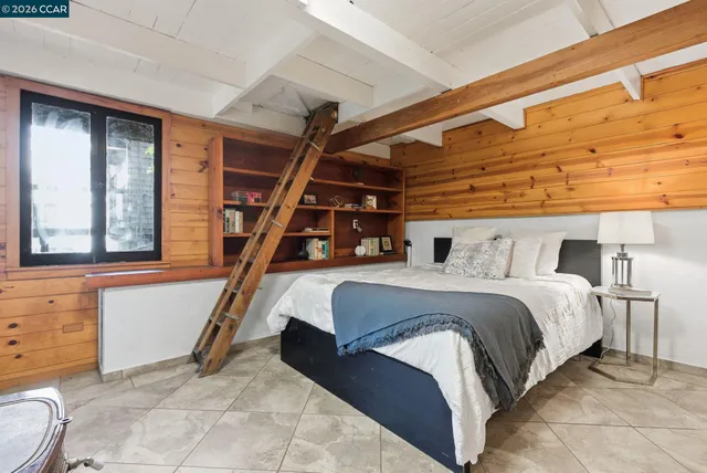 a bed sitting in a bedroom next to a window