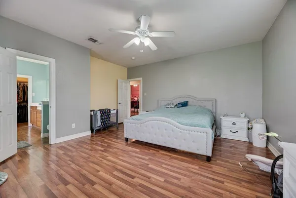 a spacious bedroom with a large bed and a chandelier