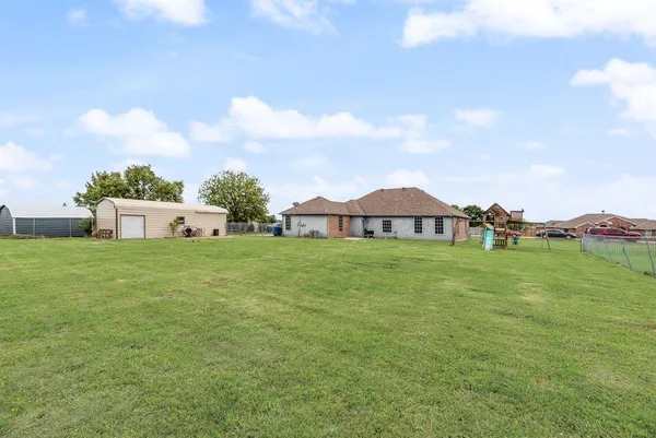 a view of a house with a big yard and a large tree