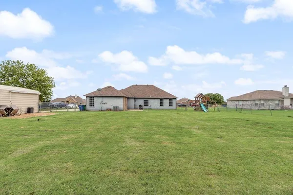 a view of backyard with house and outdoor seating