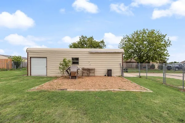 a backyard of a house with table and chairs