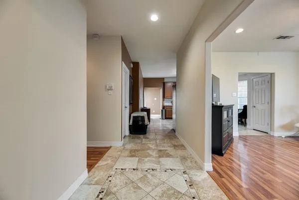 a view of a hallway with wooden floor and staircase