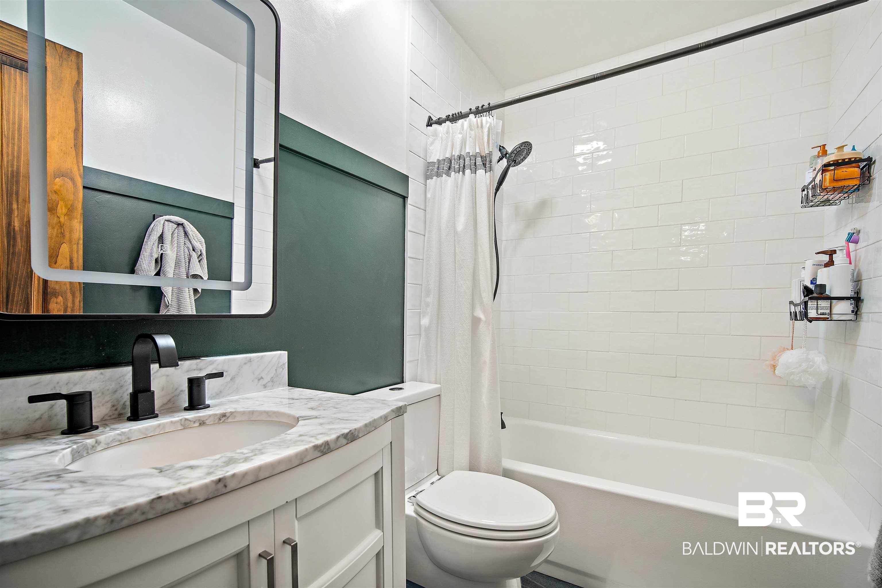 71 Caisson Trace Daphne, AL 36527 - Photo 22 of 36 Bathroom featuring a white subway tile shower, white bathtub, and dark green wainscoting