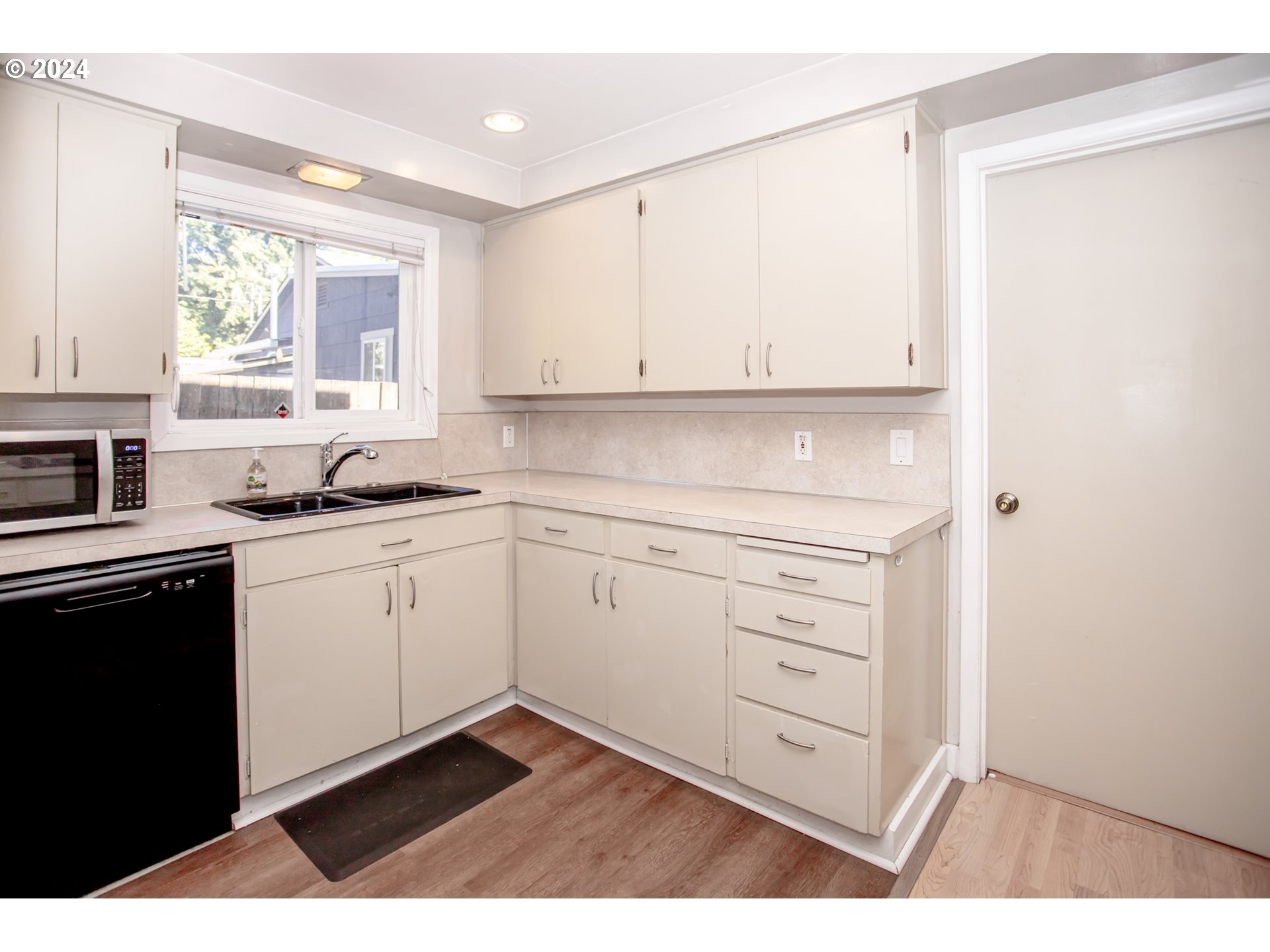 1975 Emerald Street Eugene, OR 97403 - Photo 4 of 19 a kitchen with white cabinets and window