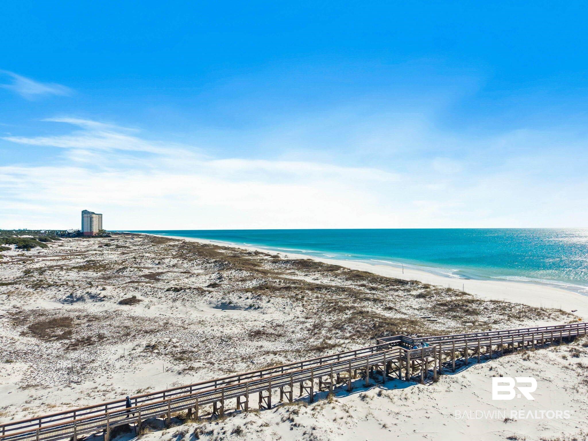 400 Plantation Road, Unit 4501 Gulf Shores, AL 36542 - Photo 25 of 30 Expansive white sand beach with a prominent wooden boardwalk structure