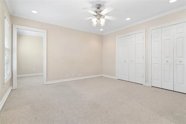 an empty room with a ceiling fan and a window