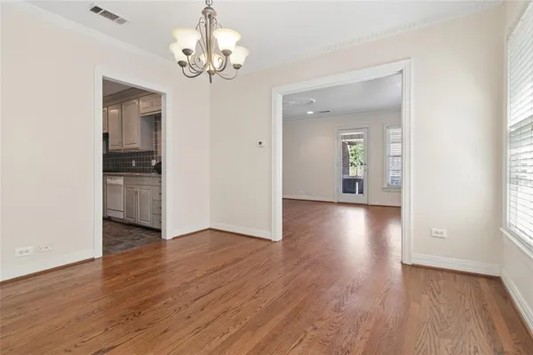 a view of a hallway with wooden floor and a chandelier