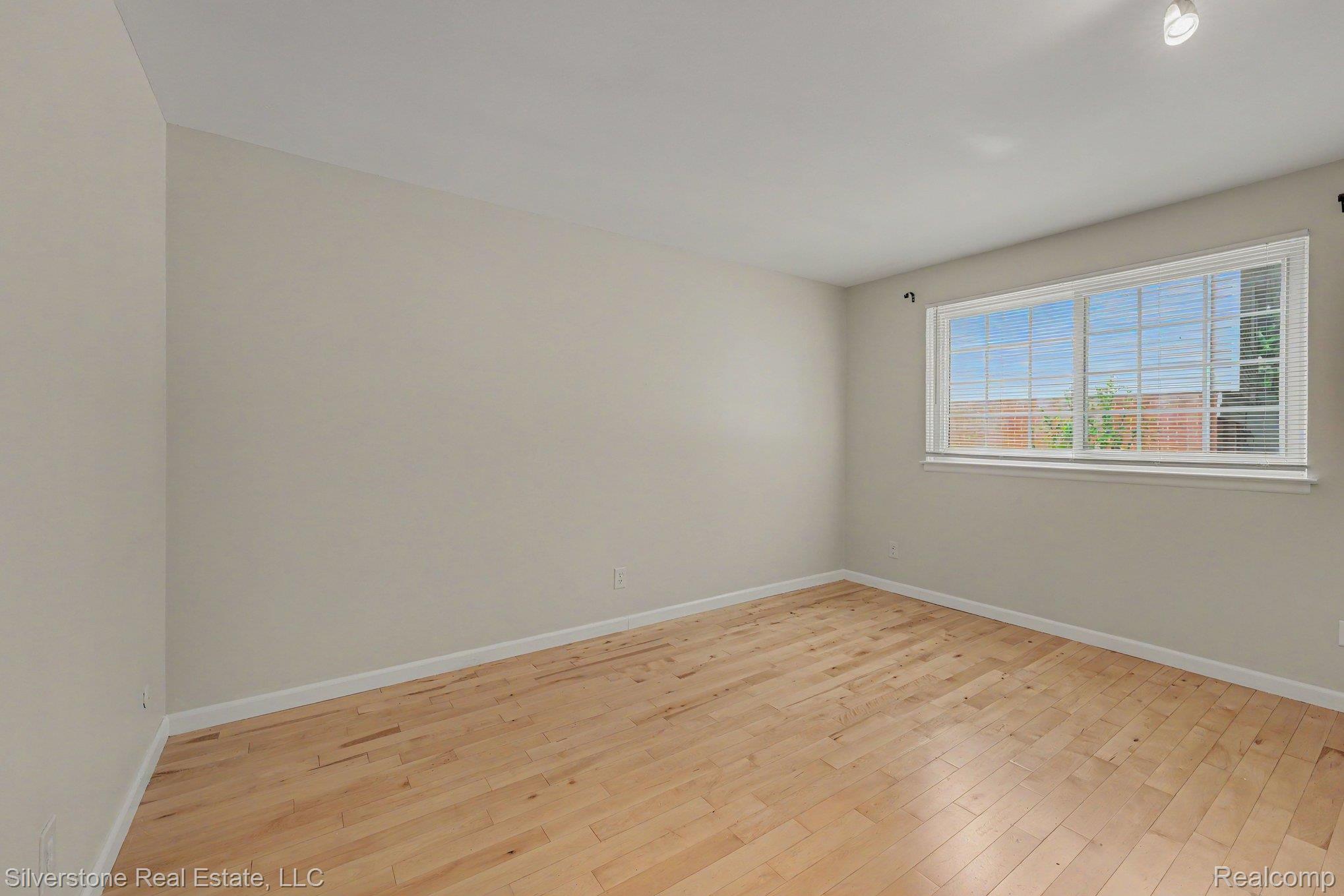 547 Reed Street Northville, MI 48167 - Photo 19 of 38 Room featuring natural wood-finish flooring, light-toned wall paint, and a large window with white blinds