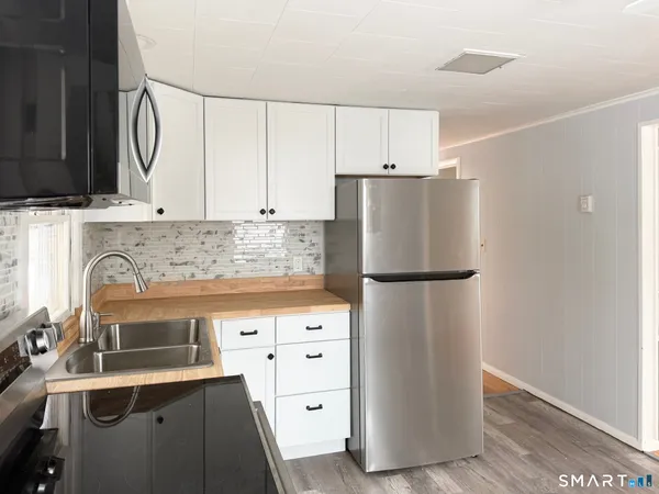 a kitchen with a refrigerator sink and cabinets