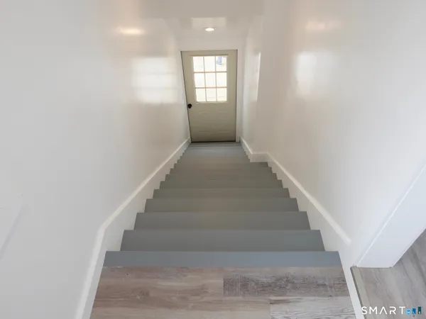 a view of entryway and hall with wooden floor