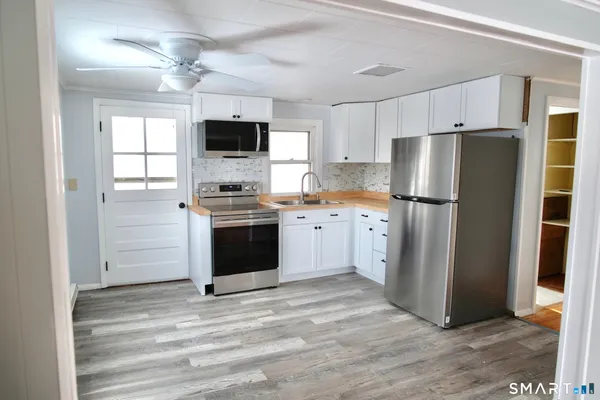 a kitchen with stainless steel appliances granite countertop a refrigerator a stove a sink and a microwave