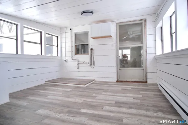 a view of empty room with wooden floor and fan