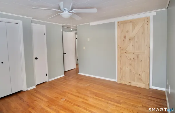 an empty room with closet and a ceiling fan