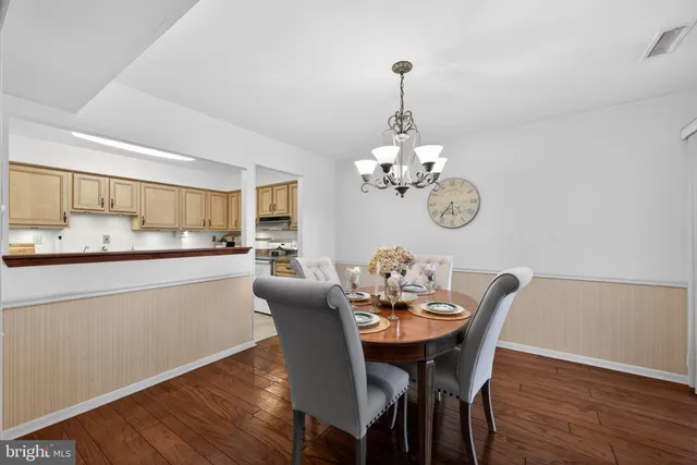 a dining room with furniture a chandelier and wooden floor