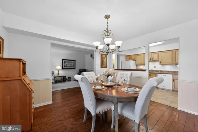 a view of a dining room with furniture a chandelier and wooden floor