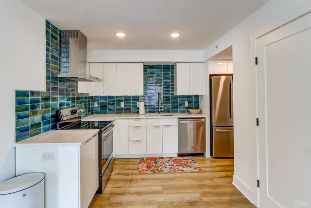 a kitchen with stainless steel appliances a refrigerator and a stove top oven