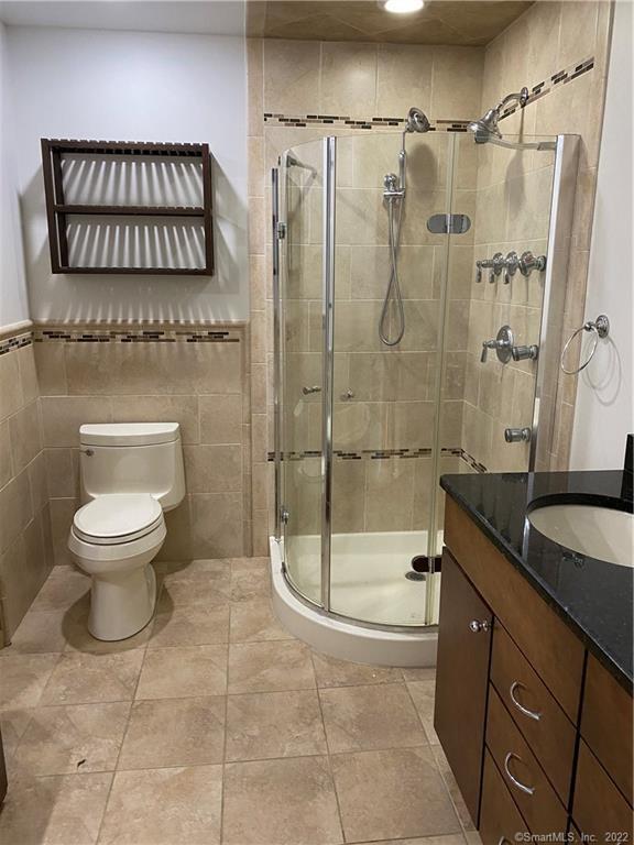 301 Post Road East, Unit 8 Westport, CT 06880 - Photo 14 of 18 a bathroom with a granite countertop sink a toilet and shower