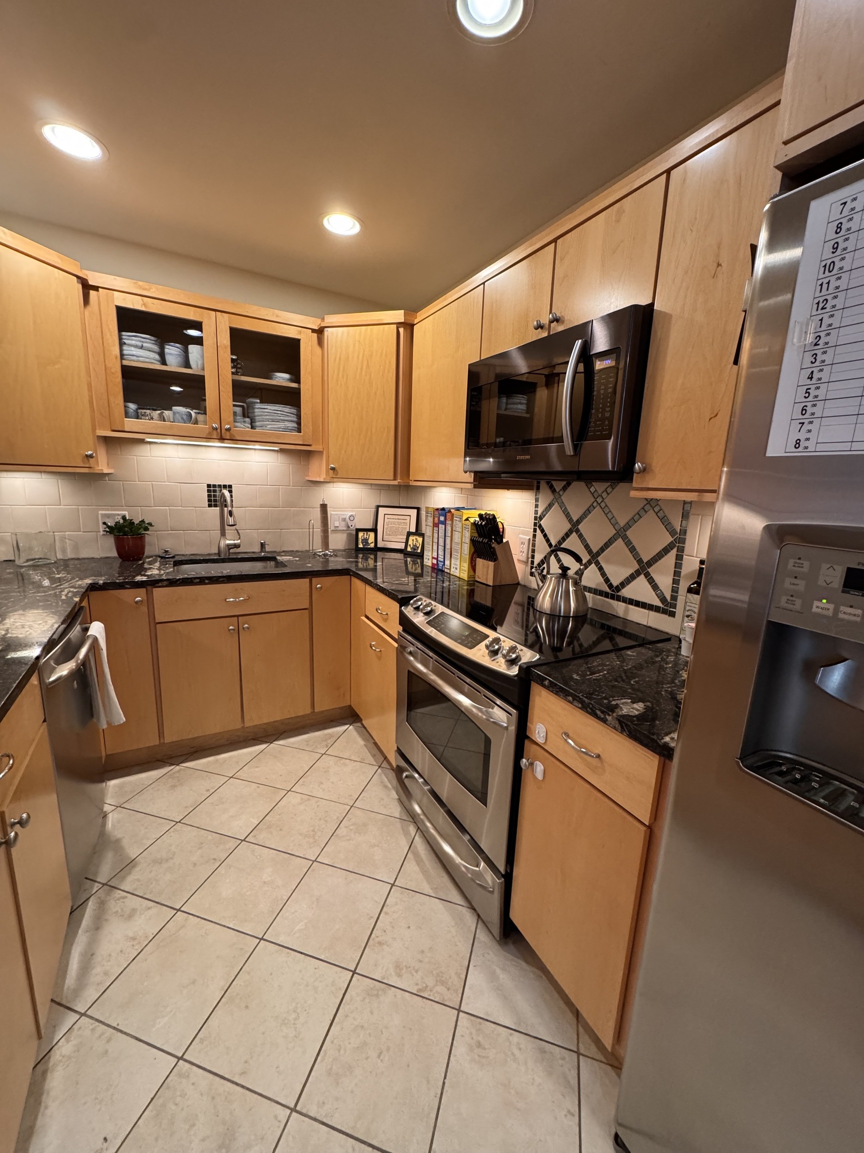 301 Post Road East, Unit 8 Westport, CT 06880 - Photo 5 of 18 a kitchen with stainless steel appliances granite countertop a sink and a stove top oven with wooden floor