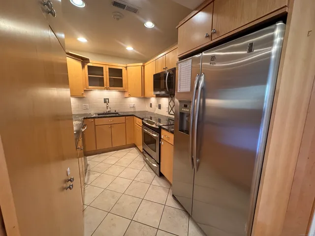 a kitchen with stainless steel appliances granite countertop a refrigerator and a sink
