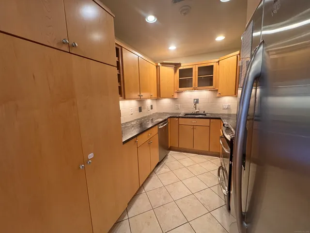 a kitchen with stainless steel appliances granite countertop a sink stove and refrigerator