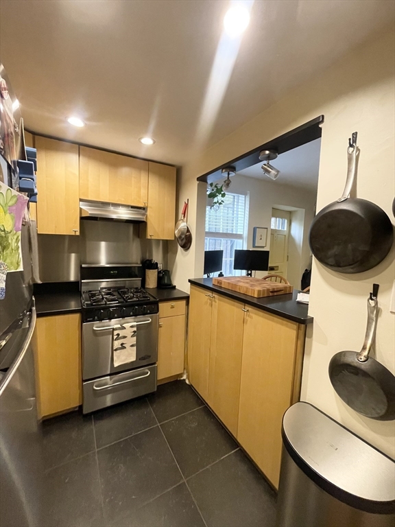 9 Primus Avenue, Unit 1 Boston, MA 02114 - Photo 10 of 19 a kitchen with stainless steel appliances granite countertop a sink a stove a microwave a counter top and cabinets