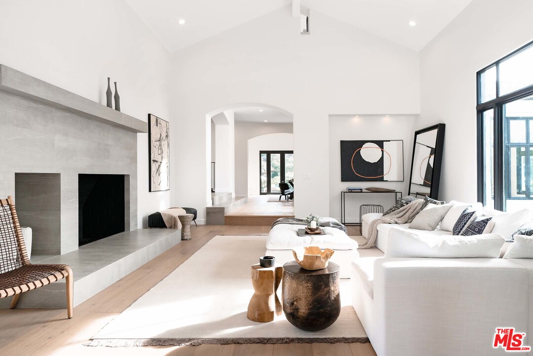 3170 Santa Maria Road Topanga, CA 90290 - Photo 13 of 60 a living room with furniture a fireplace and a flat screen tv