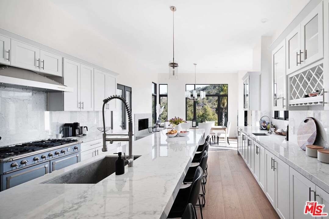 3170 Santa Maria Road Topanga, CA 90290 - Photo 19 of 60 a kitchen with stainless steel appliances kitchen island a stove a sink a refrigerator and cabinets