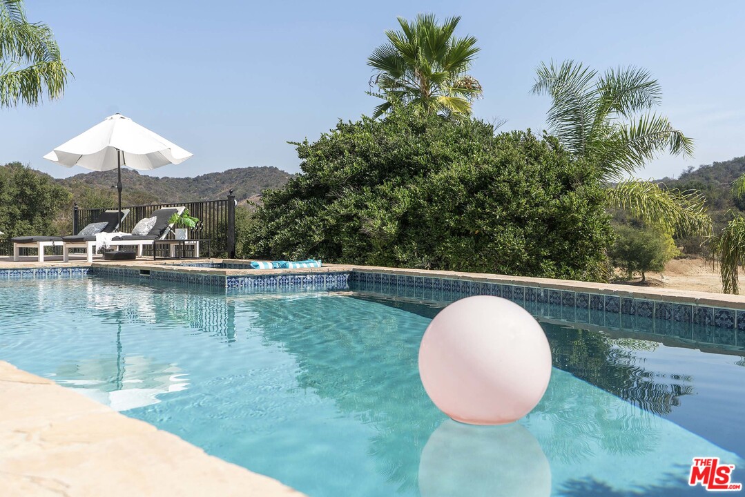 3170 Santa Maria Road Topanga, CA 90290 - Photo 7 of 60 a view of a swimming pool with a chair and tables in the patio