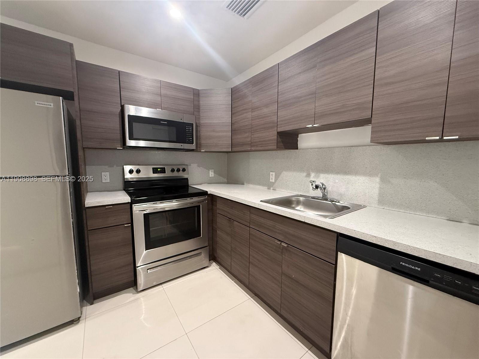 540 Northeast 67th Street, Unit 540 Miami, FL 33138 - Photo 5 of 16 a kitchen with a sink appliances and cabinets