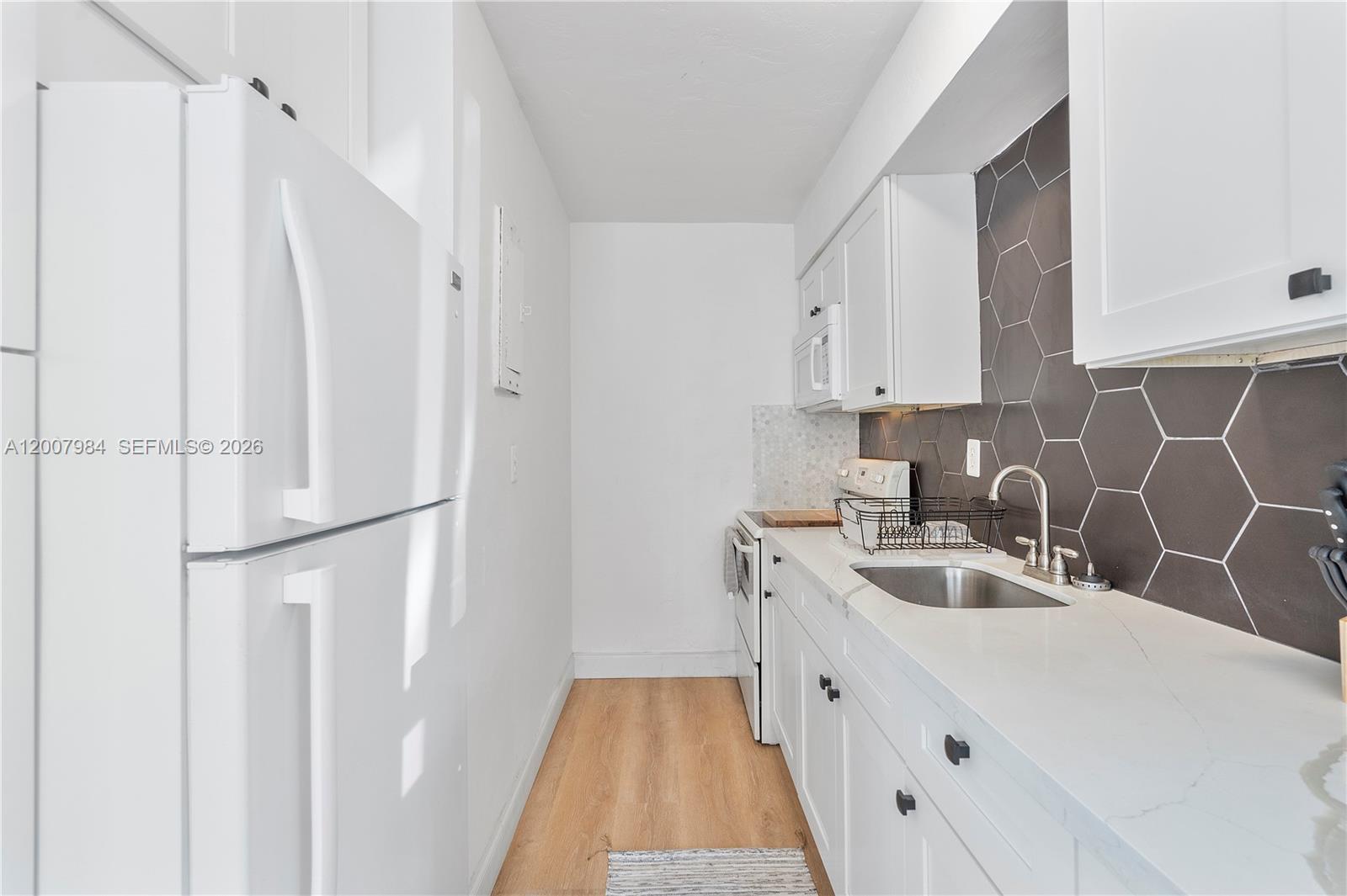 2380 Northeast 137th Street, Unit RIGHT North Miami Beach, FL 33181 - Photo 16 of 23 a kitchen with white cabinets and white appliances