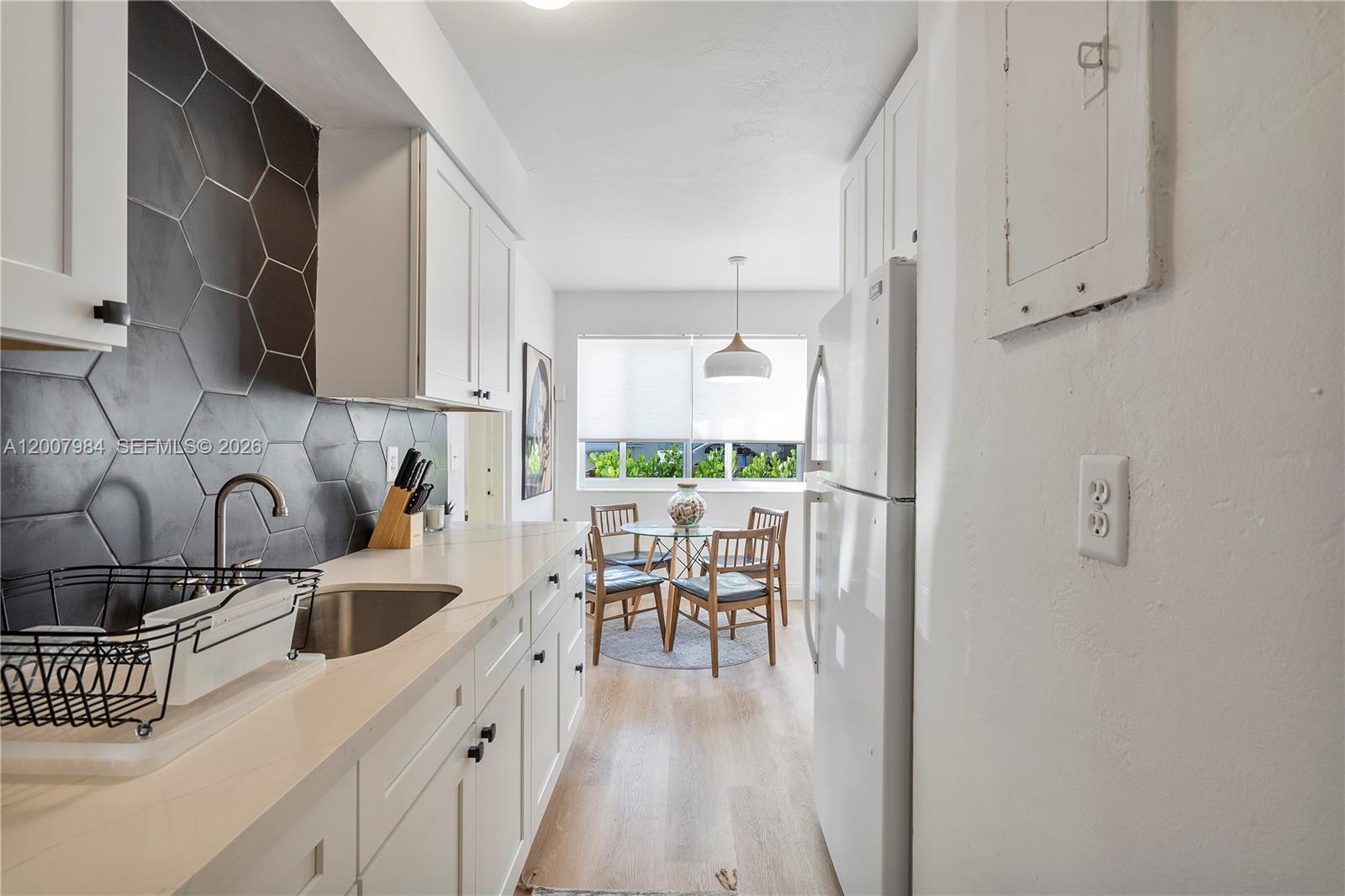 2380 Northeast 137th Street, Unit RIGHT North Miami Beach, FL 33181 - Photo 18 of 23 a kitchen with kitchen island a white counter top space a sink and appliances