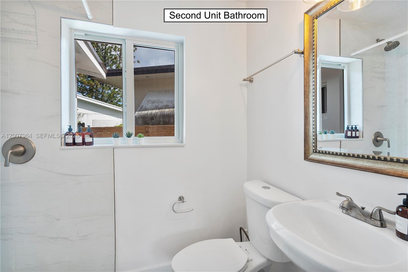 2380 Northeast 137th Street, Unit RIGHT North Miami Beach, FL 33181 - Photo 23 of 23 a bathroom with a toilet sink and mirror