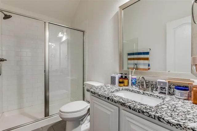 a bathroom with a granite countertop sink toilet and shower