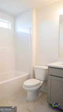 a white toilet sitting next to a bath tub