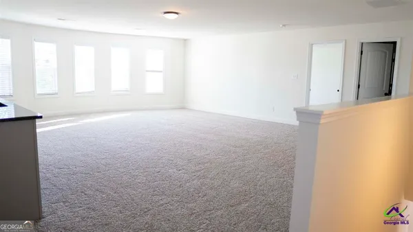 an empty room with windows and closet