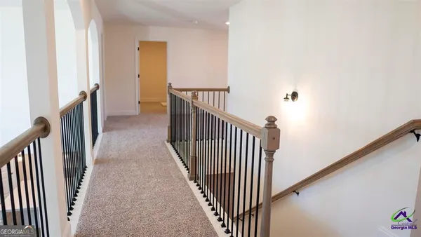 a view of a hallway with wooden floor and stairs